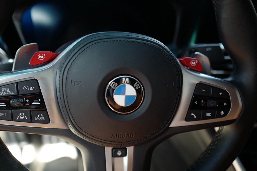 BMW M340i의 스티어링 휠에 장착된 M1 및 M2 드라이브 모드 전환 버튼 클로즈업 사진