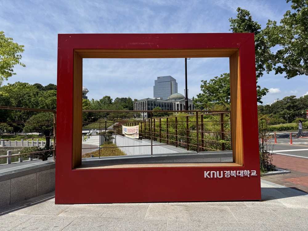'KNU 경북대학교' 라고 적힌 붉은 프레임 조형물