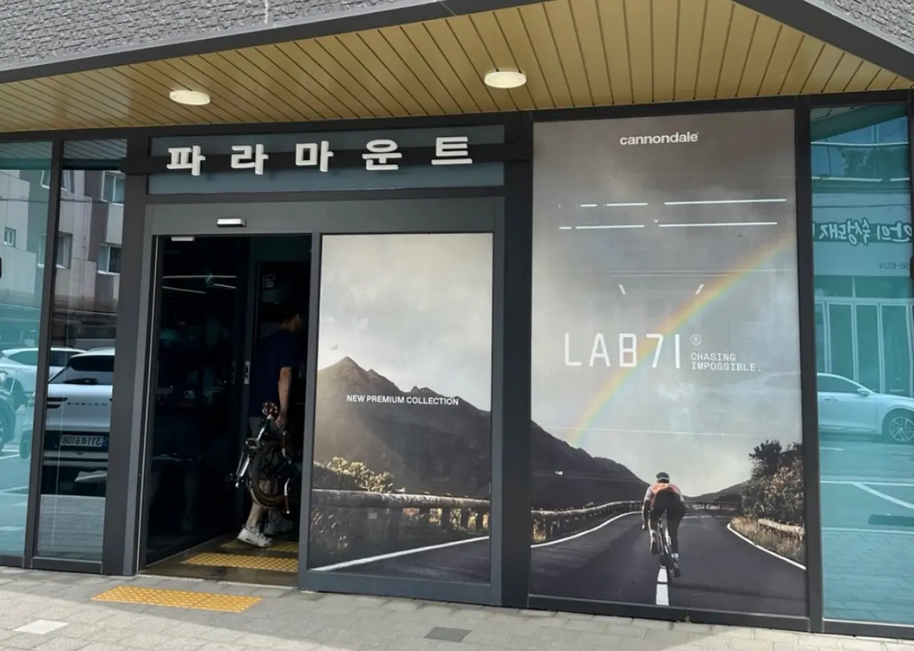 대구 브롬톤 전문 매장 파라마운트 입구 전경, LAB71 캐논데일 광고와 함께 브롬톤을 들고 들어가는 고객의 모습