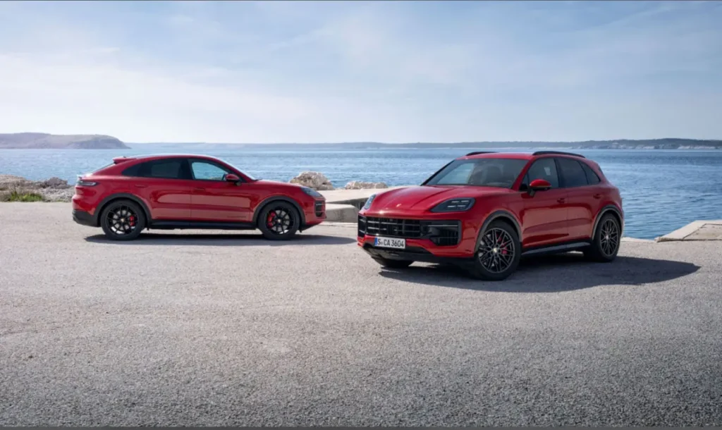 바닷가에 주차된 두 대의 붉은색 신형 포르쉐 카이엔 SUV. 2024년 포르쉐 판매량에 영향을 미친 모델 변경의 주인공인 차량.