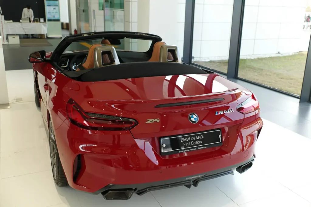 붉은색 BMW Z4 M40i 로드스터의 뒷모습. 트렁크 리드에 Z4 엠블럼과 BMW 로고, 그리고 M40i 배지가 선명하게 보인다. 오픈톱으로 내부 시트의 갈색 가죽이 살짝 보인다.