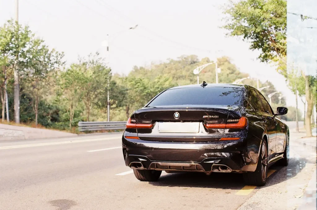 필름카메라로 촬영한 BMW M340i 후면 모습. 아날로그 특유의 따뜻한 톤과 입자감이 느껴지며 석양 빛 아래 정적인 분위기를 연출