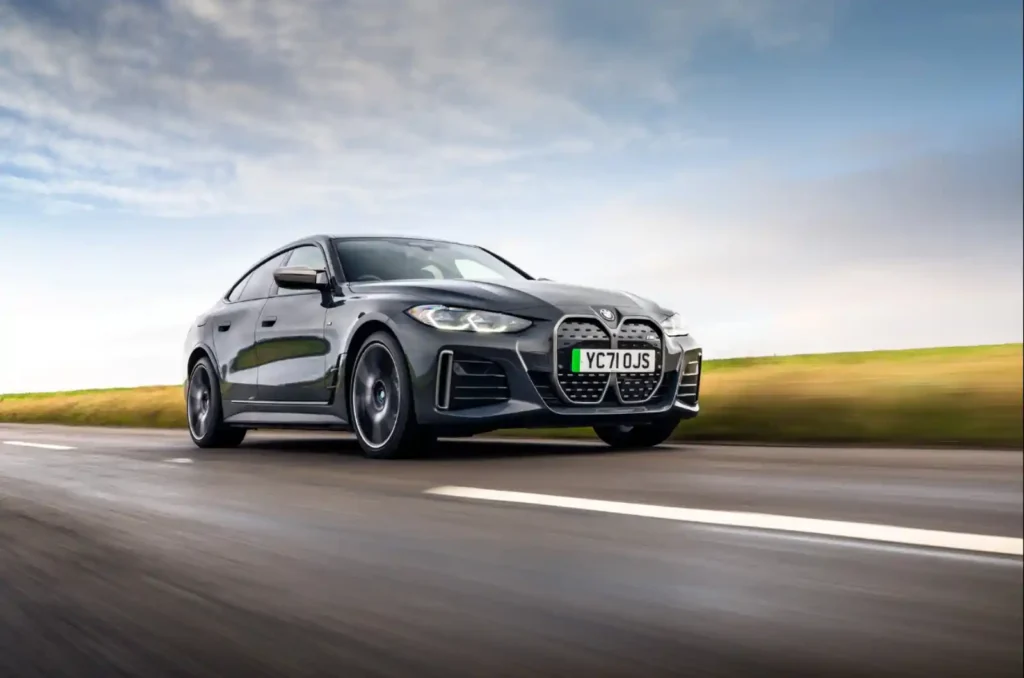 도로 위를 고속으로 달리는 회색 BMW i4 M50 전기차. 역동적인 주행 사진으로 압도적인 가속력을 시각적으로 보여줍니다.