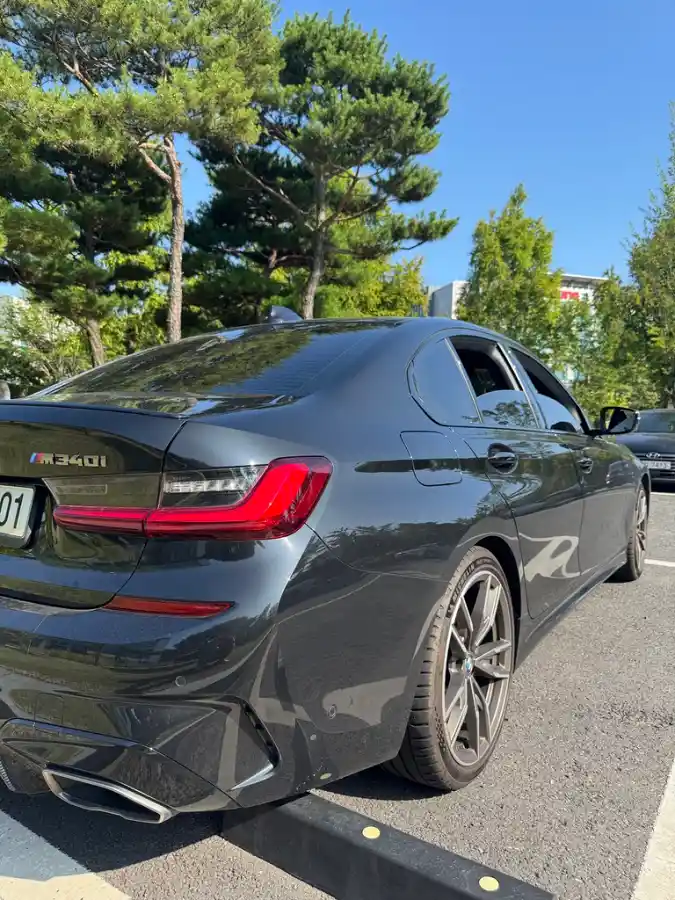 주차장에 주차된 TACO의 BMW M340i의 후면부. 트렁크에 부착된 M340i 로고와 스포티한 디자인이 눈에 띕니다.