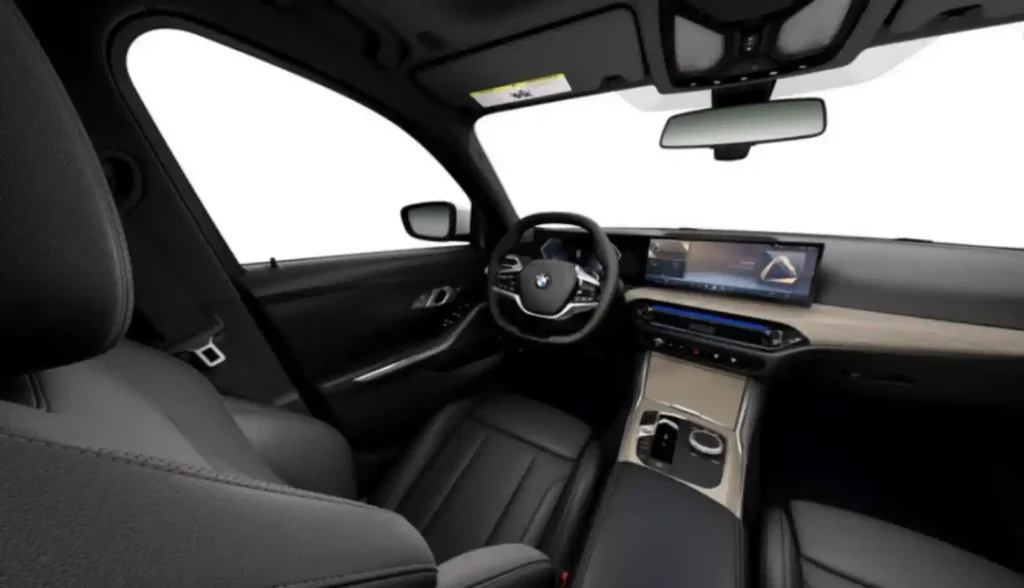 BMW 차량의 현대적인 실내. 커브드 디스플레이와 iDrive 8이 적용된 대시보드와 가죽 시트가 보임