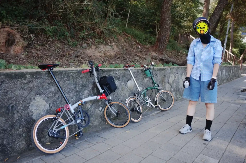 달맞이고개 오르막길에서 지친 모습의 브롬톤 부부 여행, 두 대의 브롬톤과 휴식 중인 모습