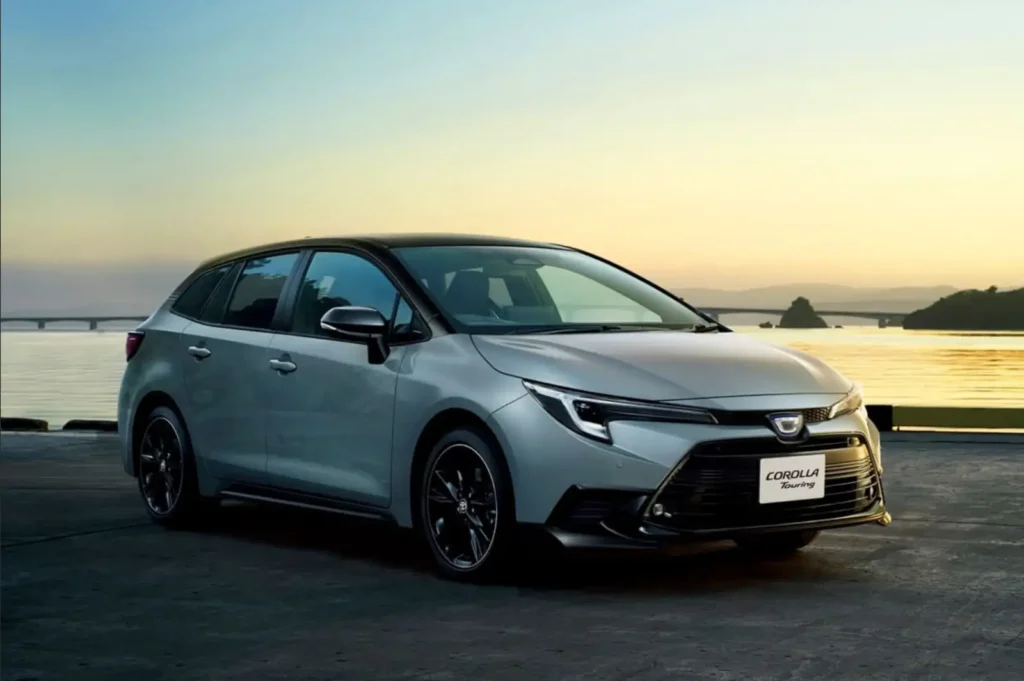 석양이 비치는 해변가에 주차된 실버 컬러의 토요타 코롤라 투어링 왜건 모습