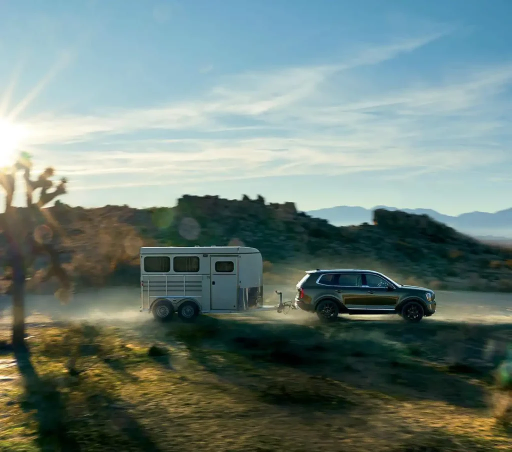 사막 지역에서 트레일러를 견인하며 주행 중인 기아 텔루라이드의 모습