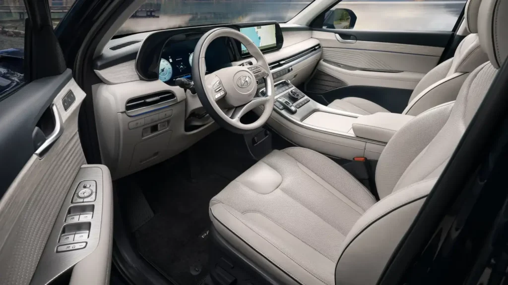 현대 팰리세이드의 고급스러운 베이지 컬러 실내와 12.3인치 대형 디스플레이가 보이는 운전석 모습