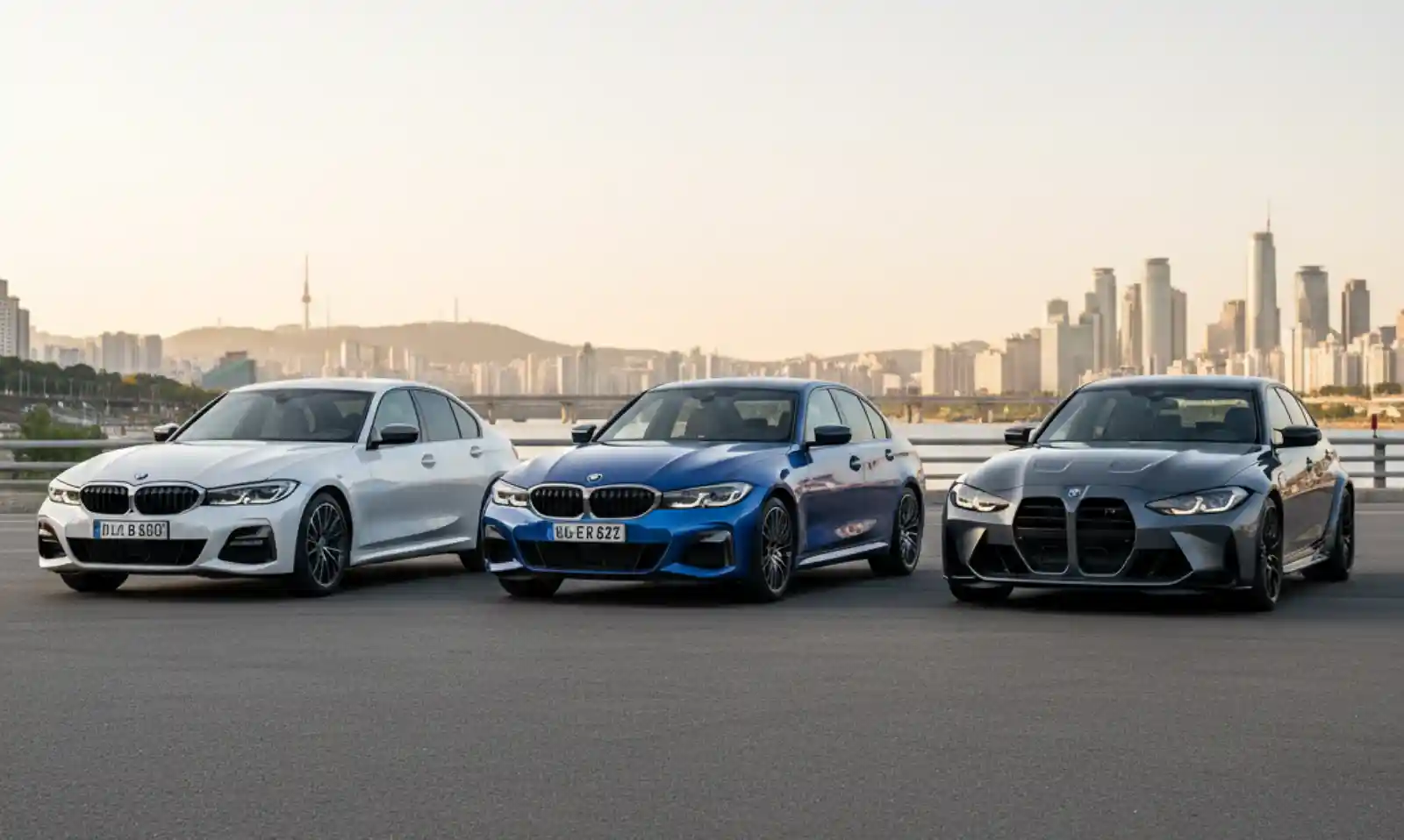 BMW 320i M340i M3 세단 3차종 비교 사진, 한강 배경 클린 아스팔트 로드에 주차된 화이트, 블루, 그레이 BMW 3시리즈. G20, G80 모델 비교.