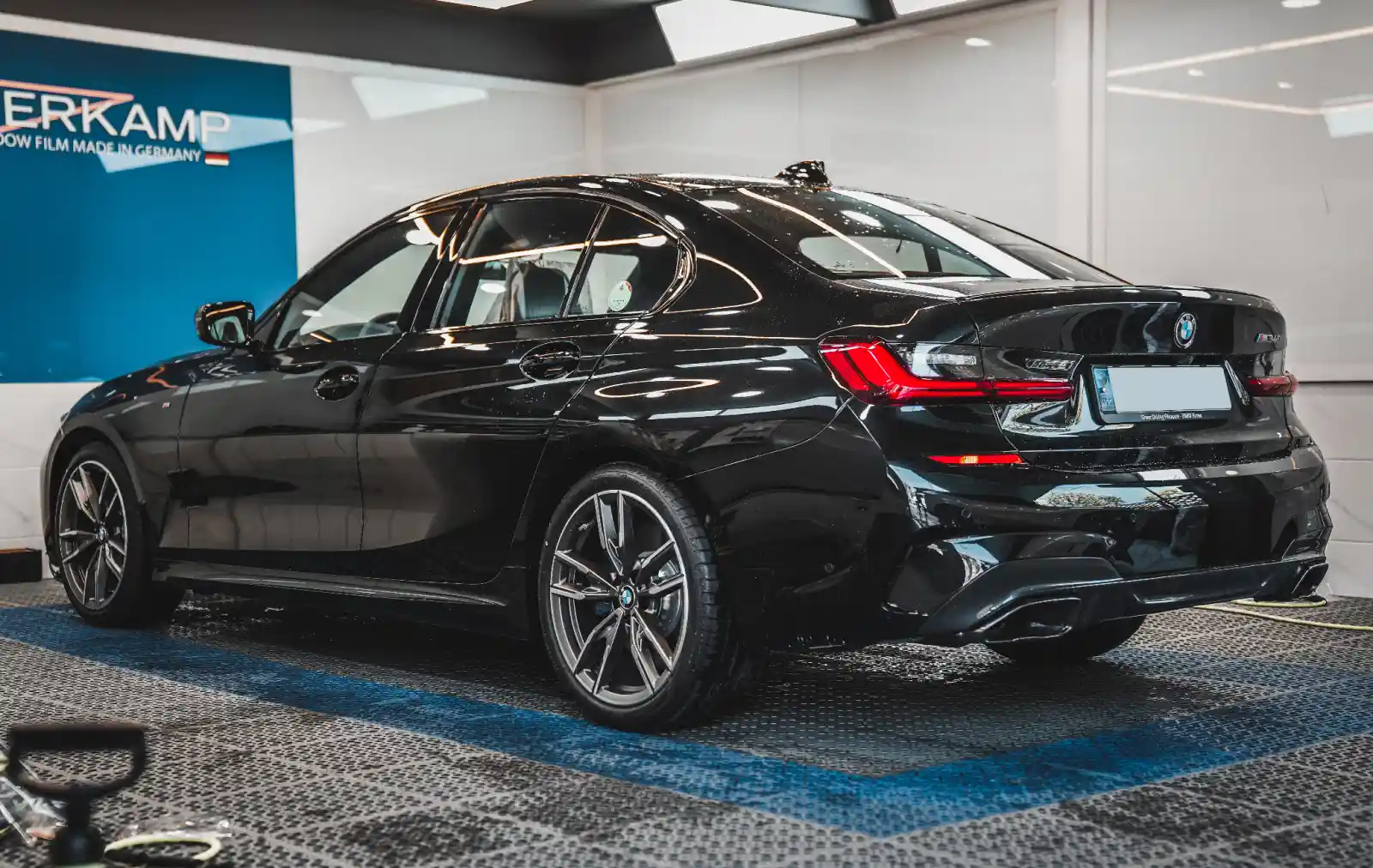 하버캠프 세라믹 틴팅을 시공한 BMW M340i가 전문 시공장에 있는 모습, 어두운 틴팅과 M스포츠 패키지의 세련된 외관