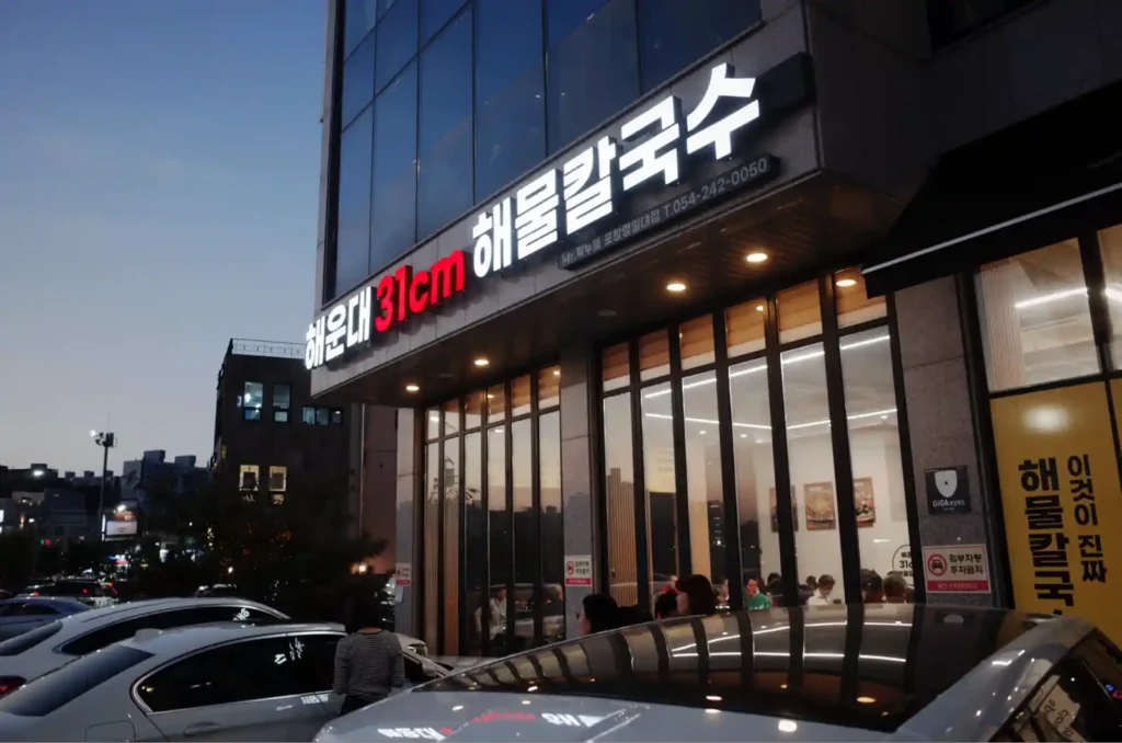 포항 죽도시장 인근 해운대31cm 해물칼국수 매장 외관과 저녁 시간 식사하는 손님들