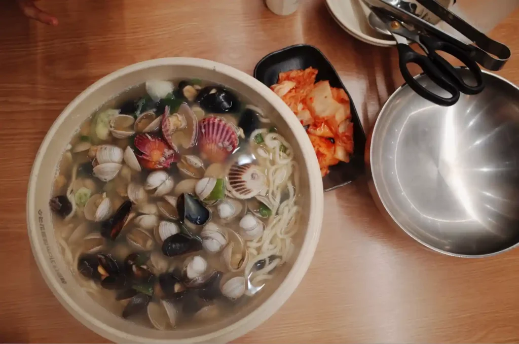 해운대31cm 해물칼국수와 김치 깍두기가 함께 차려진 식탁 모습