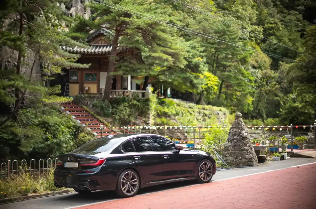 무학사 전통 사찰 입구에 주차된 BMW M340i와 배경의 전통 건축