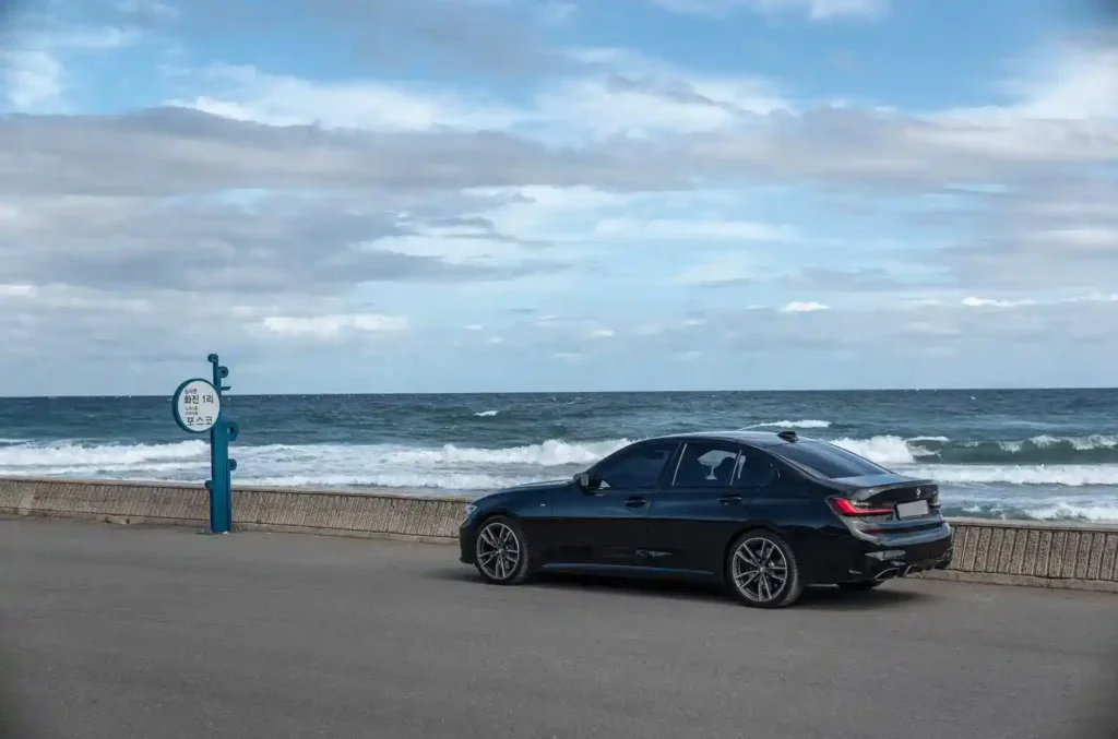 포항 화진해수욕장 가는 길, 파도가 넘실대는 바다 앞 도로에 주차된 BMW M340i