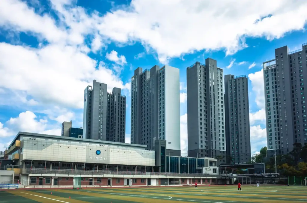 파란 하늘 아래 대구교육대학교 운동장과 그 뒤로 보이는 고층 아파트 단지의 넓은 전경