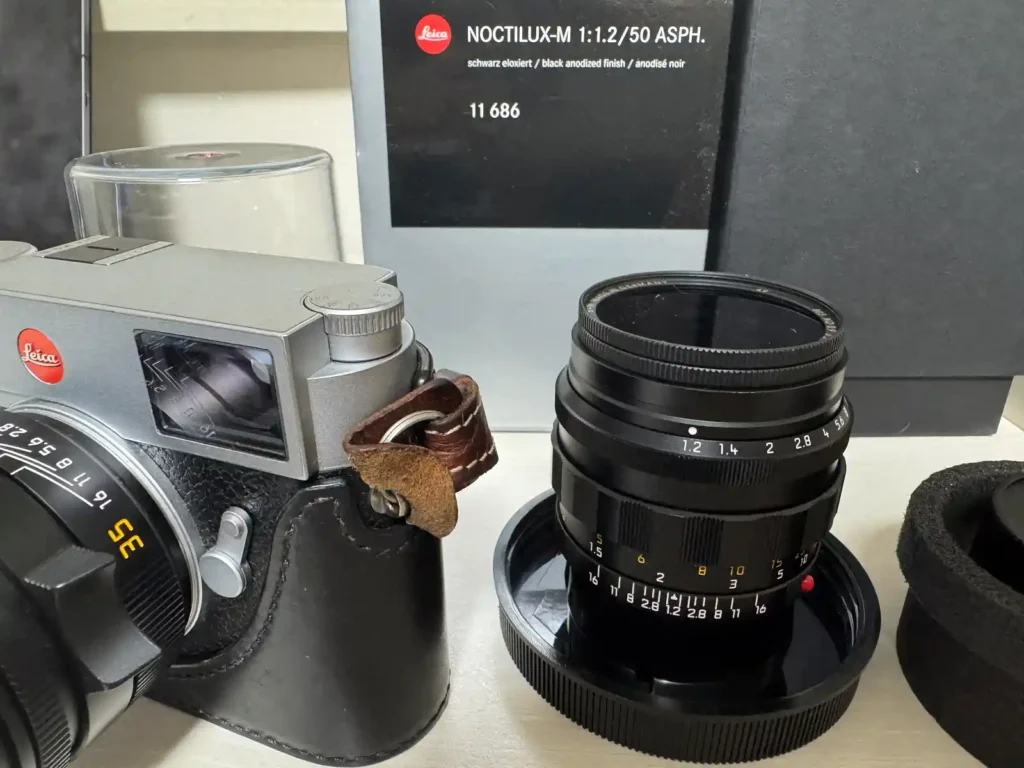 TACO의 메인 렌즈인 Noctilux-M 50mm f/1.2 ASPH 복각판과 오리지널 박스. M11-P 60MP 센서에서 몽환적이고 빈티지한 분위기를 연출하는 극강의 밝기 렌즈.