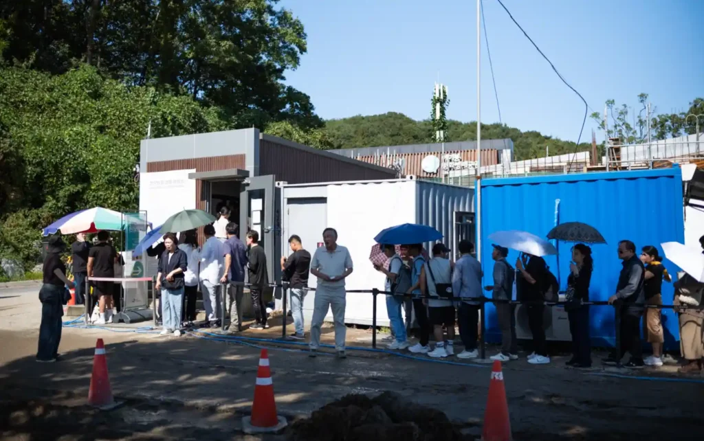 추석 연휴 다음날 애기봉평화생태공원 현장 등록소 앞에서 줄을 서 있는 방문객들. 일부는 양산을 쓰고 햇살을 피하며 차례를 기다리고 있다.