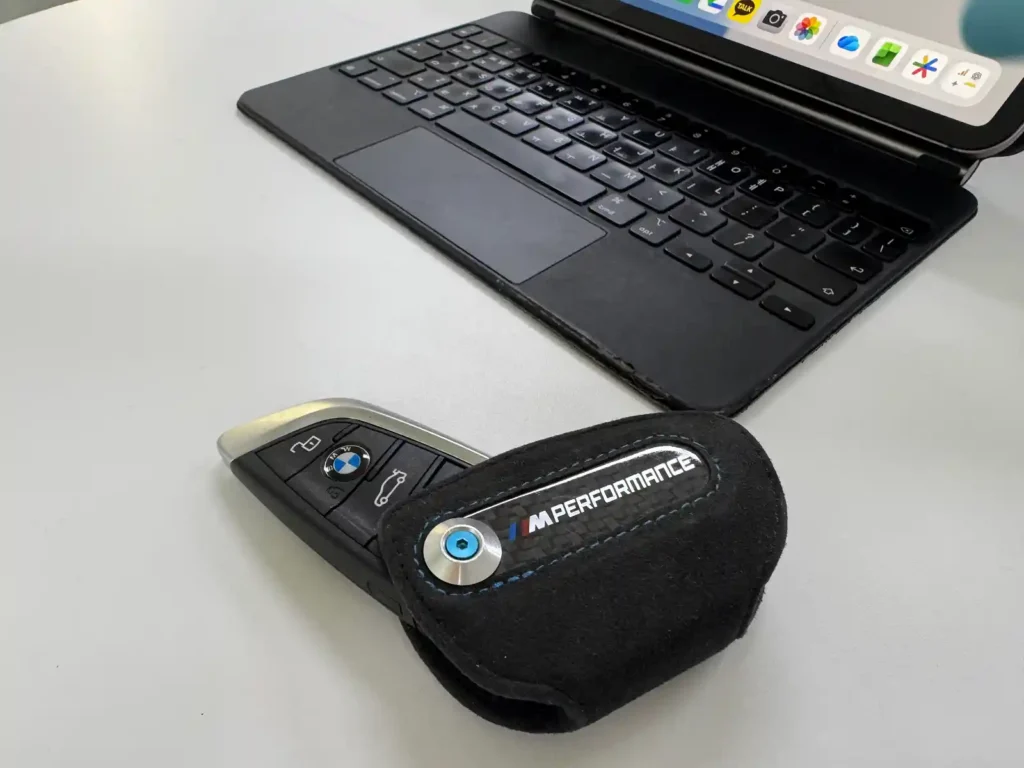 BMW M Performance carbon key case placed on desk beside iPad — detail review by TACO