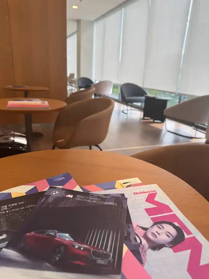 BMW 코오롱모터스 관평 서비스센터 고객 라운지 테이블에 놓인 BMW 액세서리 카탈로그와 잡지