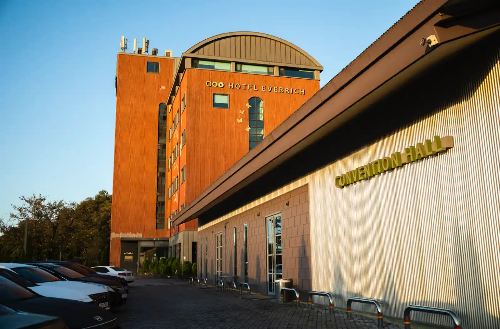 라이카 M10-R로 촬영한 강화 에버리치 호텔 외관, 주황색 벽돌 건물과 컨벤션 홀이 대비를 이루는 모습과 주차된 차량들