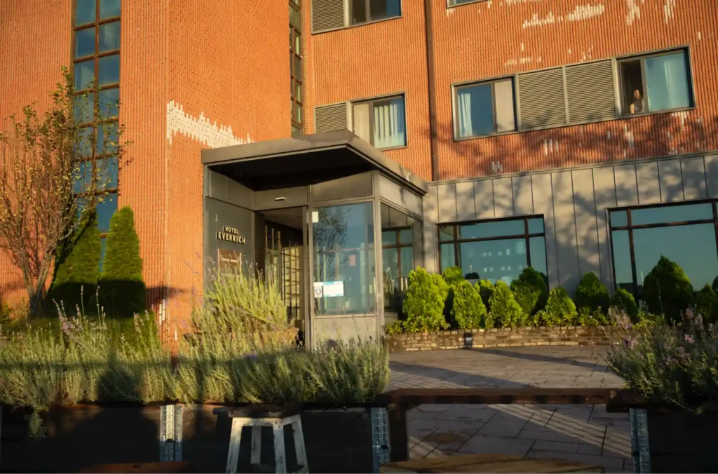 강화 에버리치 호텔 주황색 벽돌 외관 정면, 아침 햇살에 비친 HOTEL EVERRICH 입구와 깔끔하게 정돈된 정원