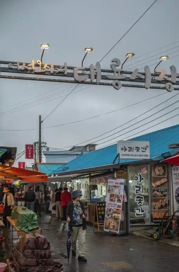 라이카 M10-R로 촬영한 교동도 대룡시장 입구 간판과 시장 골목 풍경, 우산을 쓴 방문객들과 아리곳간 약과 가게