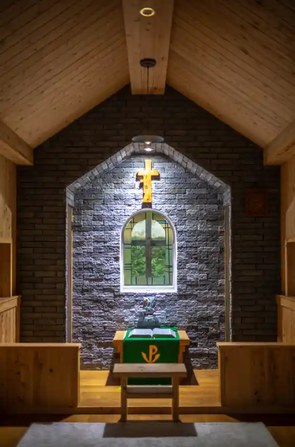 교동도 순례자의 교회 내부, 제단 뒤 십자가와 스테인드글라스 창문, 검은색 벽돌과 나무 천장