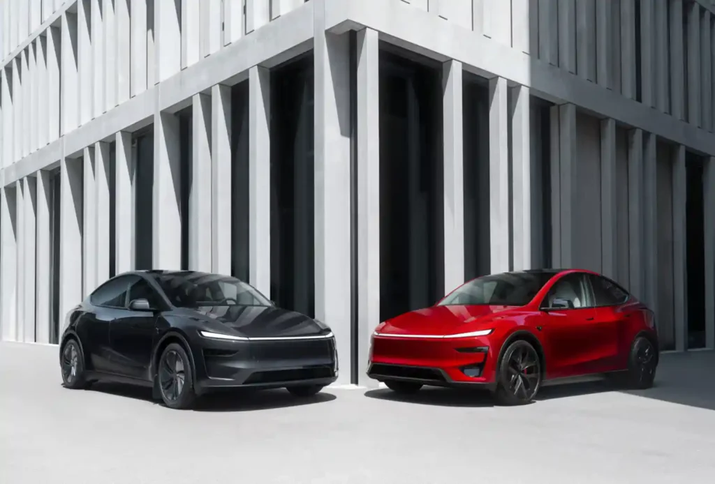 현대적인 건물 앞 좌우에 나란히 주차된 검은색과 빨간색 테슬라 모델 Y 부분변경(주니퍼) 전기차.