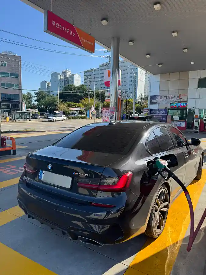 주유소에서 주유 중인 검은색 BMW M340i 후면. 주유 건이 주유구에 꽂혀있고 주변으로 노란색 선이 보인다. 내연기관 오너가 전기차 전환을 고민하는 포스팅 도입부에 사용되는 사진.