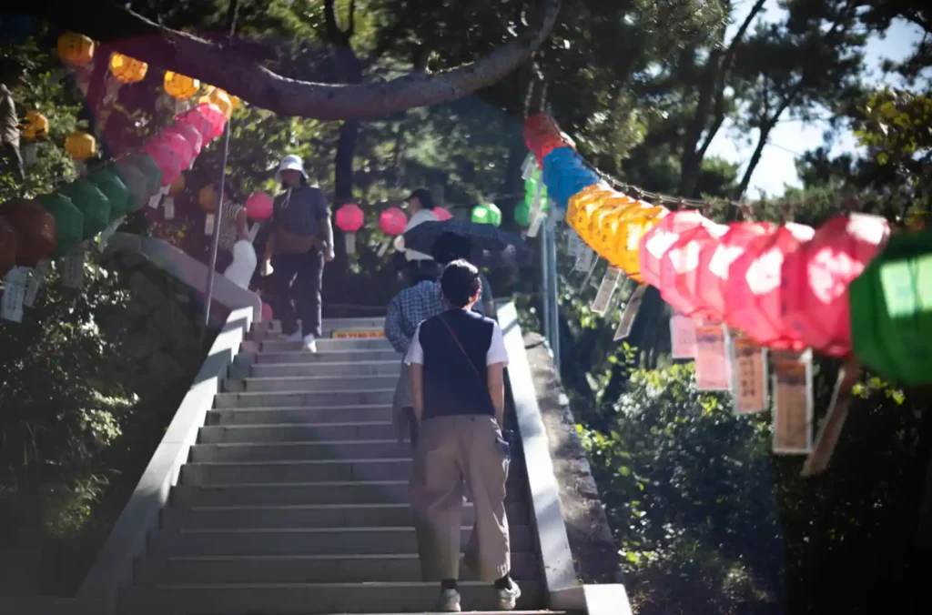 석모도 보문사 마애관음보살좌상 419계단 입구, 형형색색의 연등 터널 아래 계단을 오르는 참배객들 스냅
