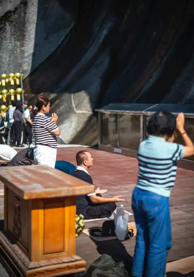 마애관음보살좌상 앞, 줄무늬 티셔츠를 입은 여성들이 간절하게 기도하는 순간, 녹티룩스 f/1.2 클로즈업 스냅