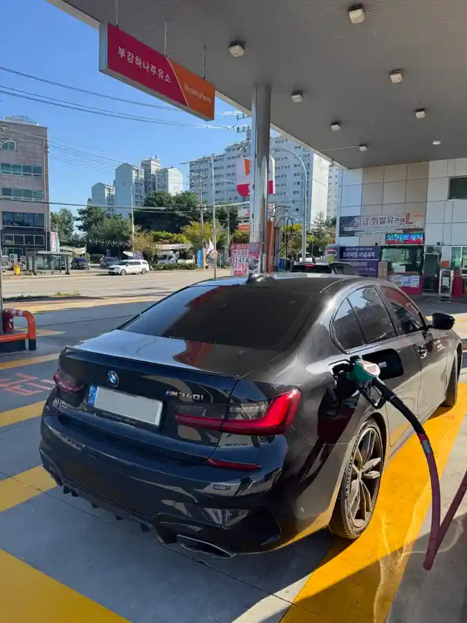 주유소에서 주유 중인 검은색 BMW M340i 후면. 주유 건이 주유구에 꽂혀있고 주변으로 노란색 선이 보인다. 내연기관 오너가 전기차 전환을 고민하는 포스팅 도입부에 사용되는 사진.