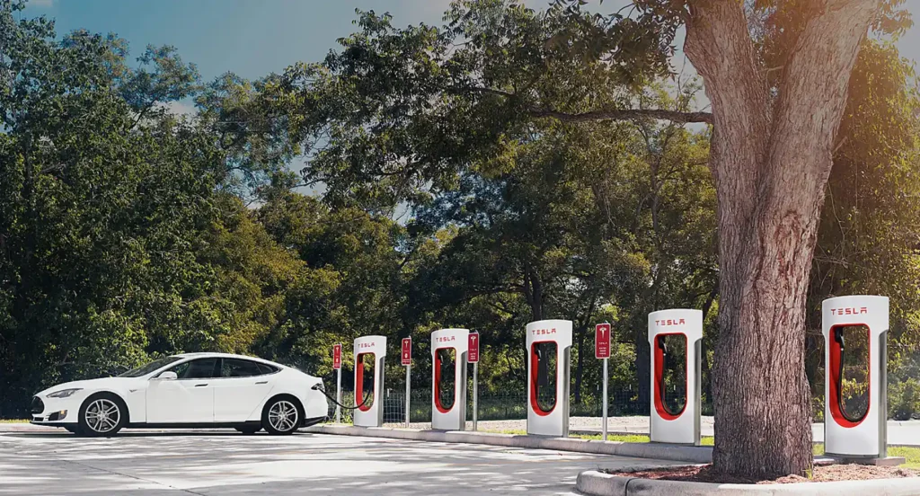 테슬라 슈퍼차저 스테이션에서 충전 중인 차량 — 글로벌 전기차 인프라의 상징적인 장면