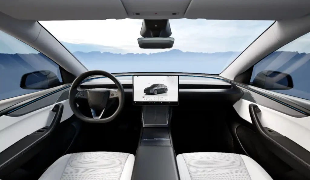 테슬라 모델 Y의 미니멀한 인테리어 — 중앙 디스플레이 중심의 간결하고 정제된 운전석 전경