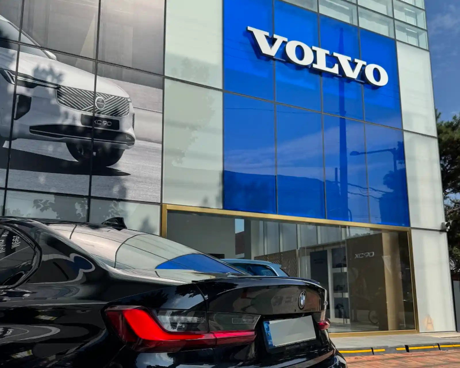 BMW M340i parked in front of the Volvo Daegu showroom before EX30 Cross Country test drive