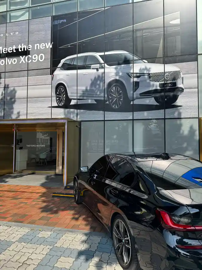 BMW M340i parked in front of the Volvo Daegu showroom entrance before EX30 Cross Country test drive