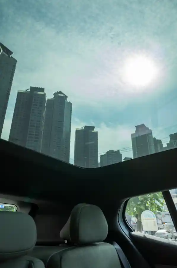 Panoramic glass roof of Volvo EX30 Cross Country showing open sky and sunlight view from rear seat