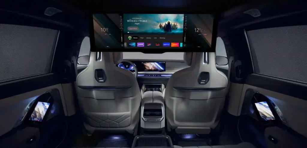 BMW i7의 2열에 장착된 32:9 초대형 시어터 스크린과 라운지형 뒷좌석 공간을 보여주는 실내 이미지