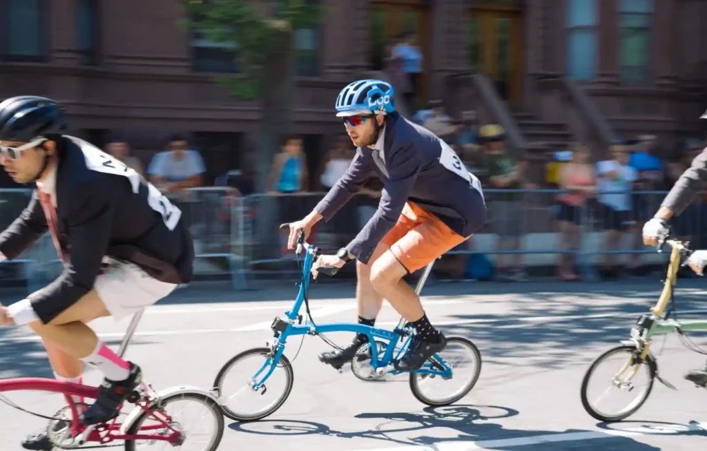 정장 차림의 참가자들이 브롬톤을 타고 속도를 내며 경주 중인 모습