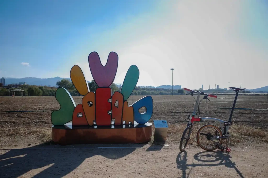 대구 금호꽃섬 하중도 들판에 전시된 조각 작품과 브롬톤 자전거