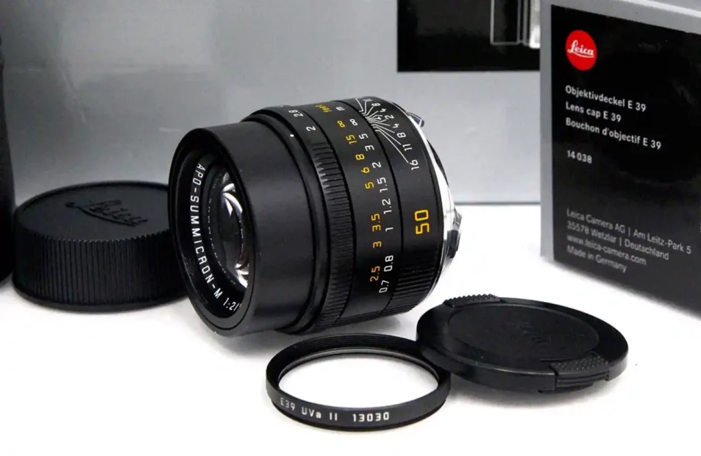 라이카 APO-Summicron-M 50mm f/2.0 ASPH 렌즈와 렌즈 후드, UV 필터, 정품 박스가 함께 놓여있는 모습