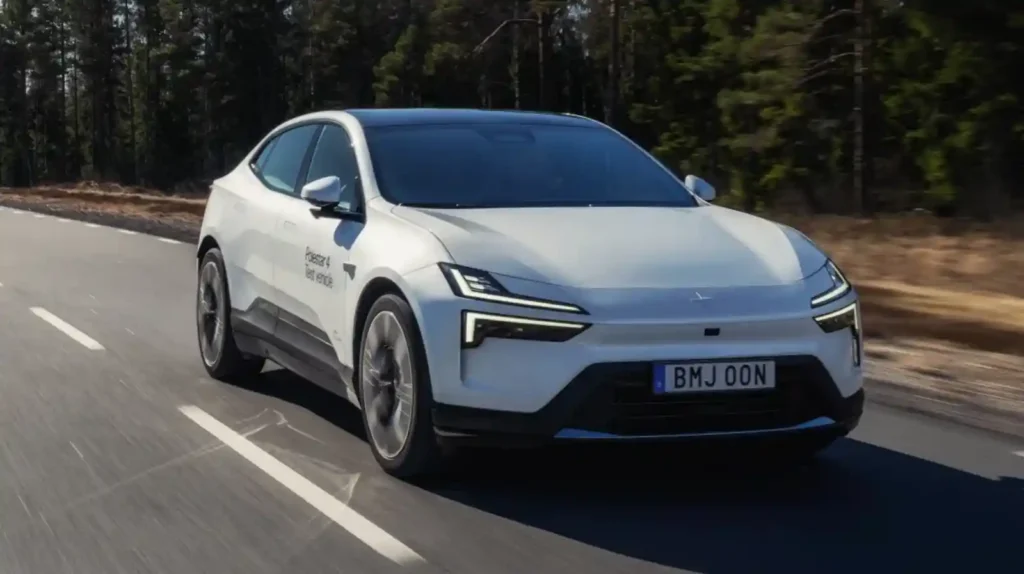 숲길 도로에서 주행 중인 Polestar 4 테스트 차량의 전면 모습