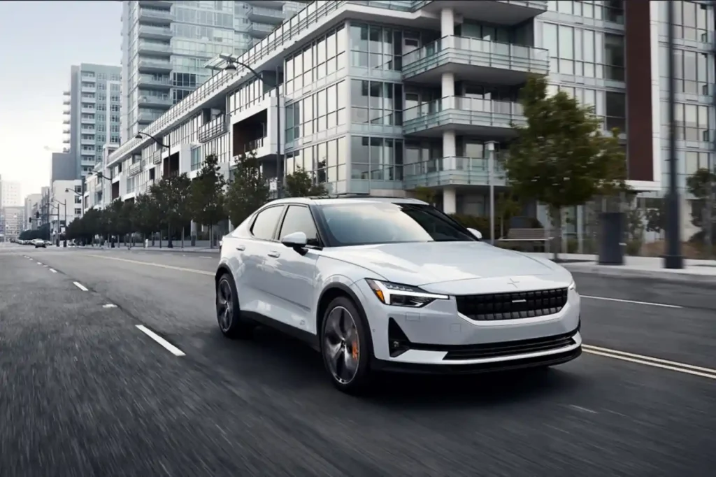 도심 도로를 빠르게 주행 중인 Polestar 2의 3/4 프론트 뷰