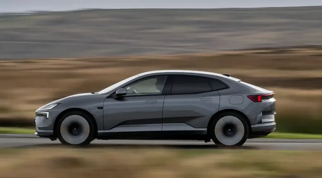 고속 주행 중인 Polestar 4의 측면 모습으로, 부드럽고 안정적인 쿠페형 SUV 실루엣이 강조된 장면