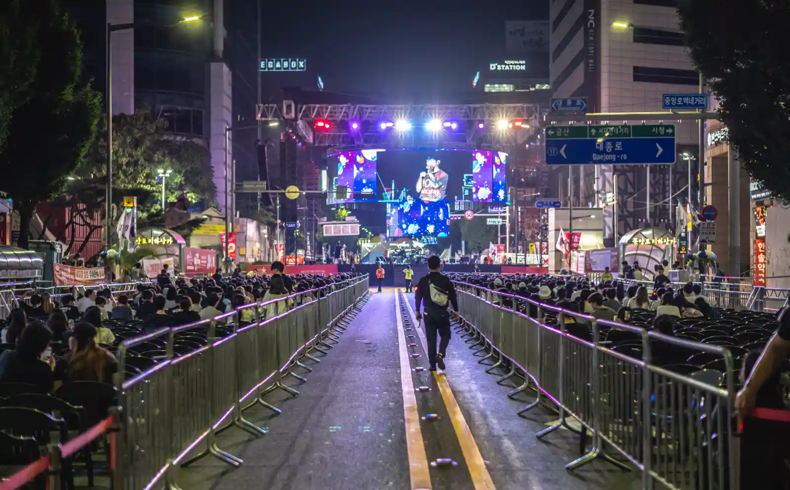 대전 영시 축제 야간 공연장, 중앙 통로를 따라 무대로 이어지는 조명과 관객들, Leica M10-R과 Noctilux 50mm f/1.2로 촬영한 저조도 거리 사진