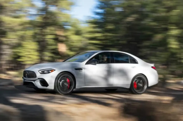 숲길을 고속으로 달리는 신형 메르세데스 AMG C63 S E 퍼포먼스의 주행 장면