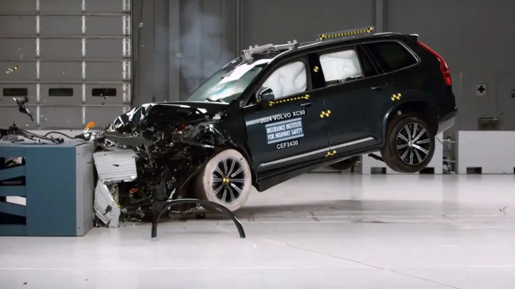 볼보 XC90 IIHS 충돌 테스트 장면, 에어백 전개 및 차체 변형 상태를 보여주는 안전성 테스트 이미지