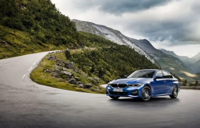 BMW M340i가 북유럽 산악 도로를 달리는 모습, 파란색 차체와 구불구불한 와인딩 로드