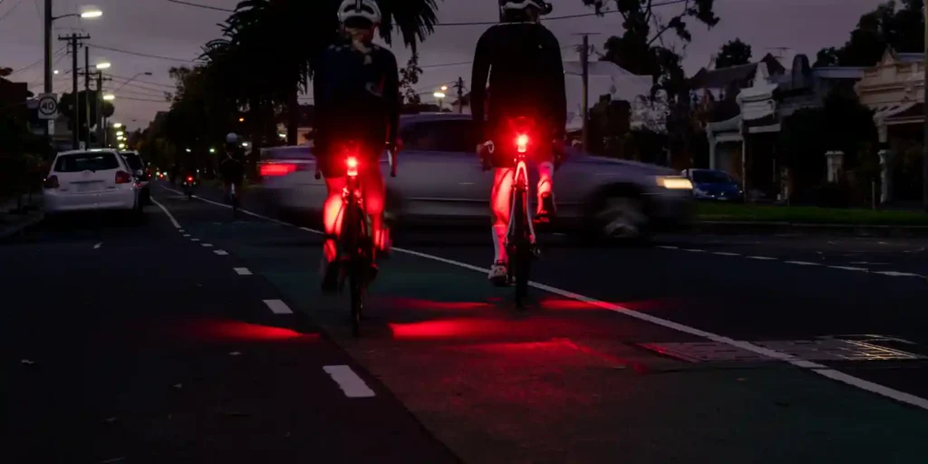 야간 도로에서 후미등을 켠 자전거 라이더들의 후방 시인성